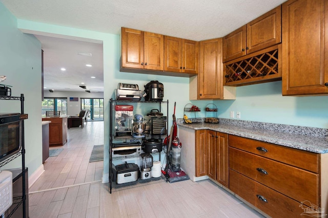 kitchen with light stone counters and a textured ceiling