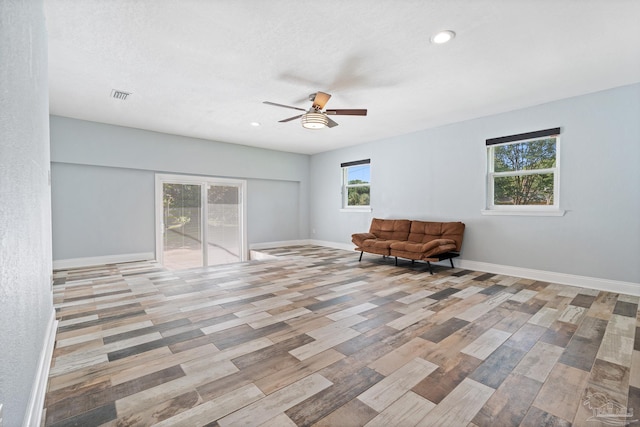 unfurnished room with plenty of natural light, light wood-type flooring, and ceiling fan