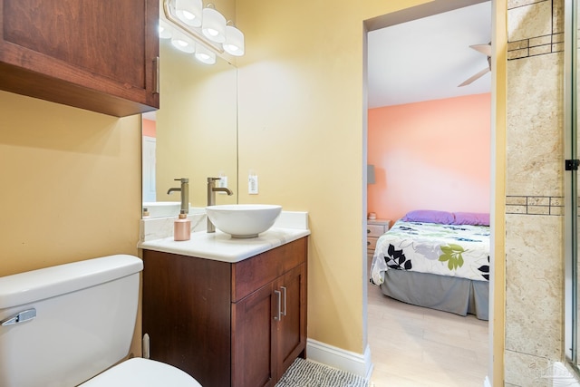 bathroom with vanity, toilet, and ceiling fan