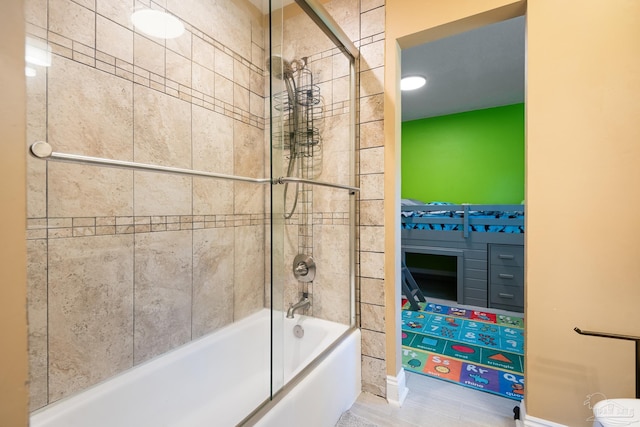 bathroom featuring tile patterned flooring and bath / shower combo with glass door