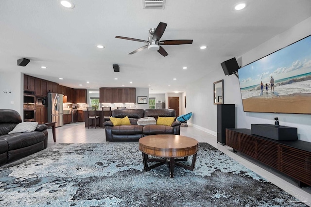 living room featuring light hardwood / wood-style flooring and ceiling fan