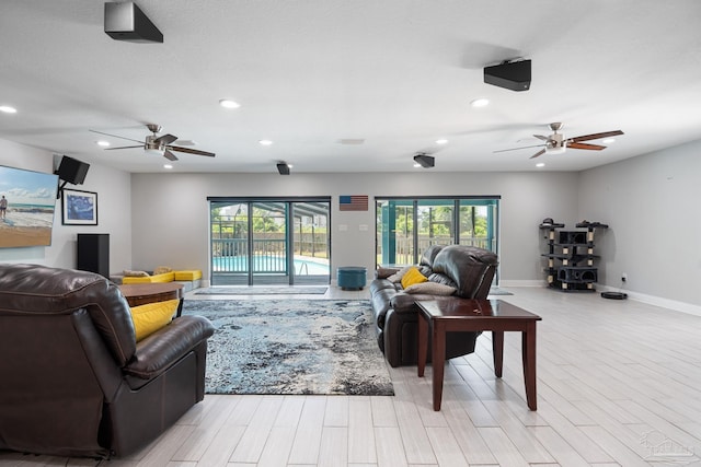 living room featuring ceiling fan and light wood-type flooring