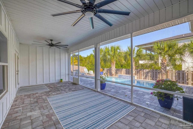 unfurnished sunroom with ceiling fan