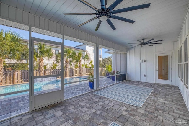 unfurnished sunroom with ceiling fan