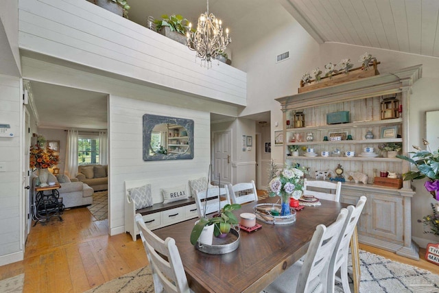 dining area featuring light wood-type flooring, lofted ceiling, and a notable chandelier