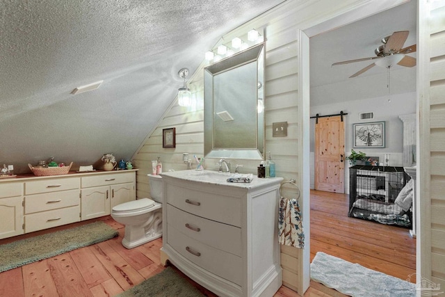 bathroom featuring vanity, ceiling fan, hardwood / wood-style floors, toilet, and a textured ceiling