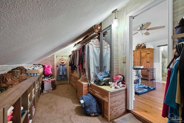 walk in closet with light carpet, vaulted ceiling, and ceiling fan