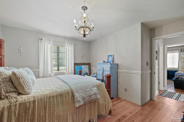 bedroom with hardwood / wood-style flooring and a notable chandelier