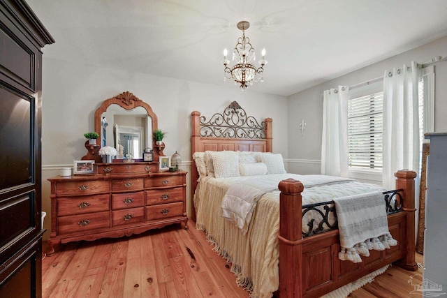 bedroom featuring light hardwood / wood-style flooring and an inviting chandelier