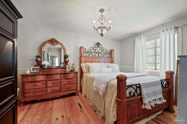 bedroom with a chandelier and light hardwood / wood-style floors