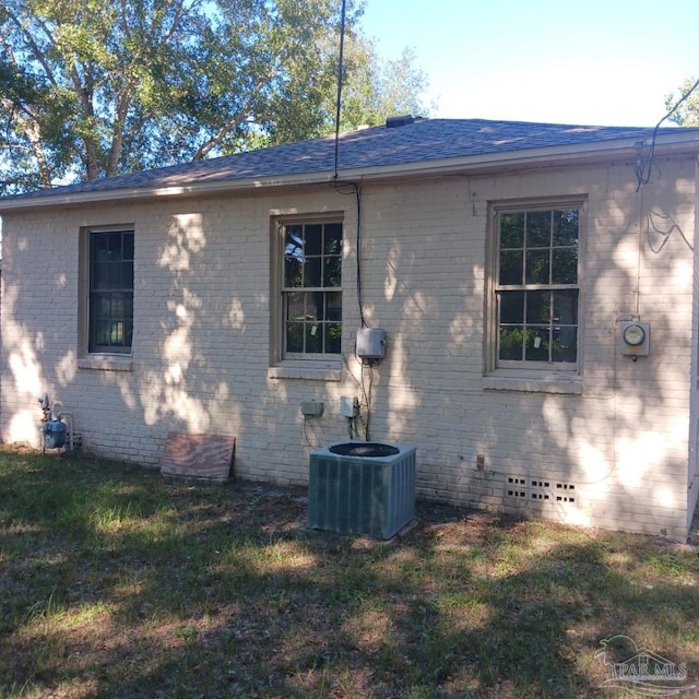 view of side of home with a lawn and central AC unit