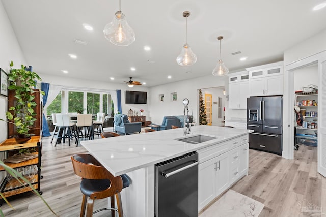 2032 Bay Point Blvd, Milton, FL 32583 - kitchen with fridge with ice dispenser, dishwasher, a ceiling fan, an island with sink, and white cabinetry