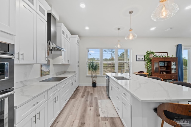2032 Bay Point Blvd, Milton, FL 32583 - kitchen featuring stainless steel appliances, light wood finished floors, a kitchen island with sink, white cabinetry, and recessed lighting