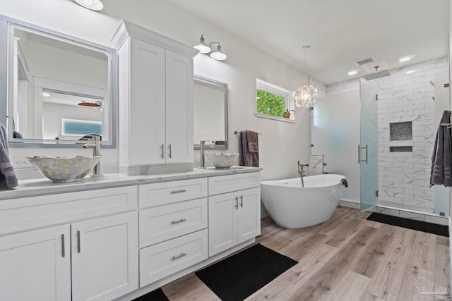 2032 Bay Point Blvd, Milton, FL 32583 - bathroom with a shower stall, double vanity, a soaking tub, wood finished floors, and recessed lighting