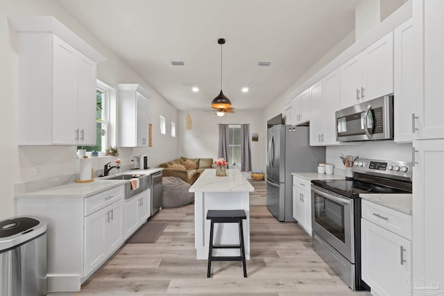2032 Bay Point Blvd, Milton, FL 32583 - kitchen featuring stainless steel appliances, white cabinets, recessed lighting, light wood-style floors, and open floor plan
