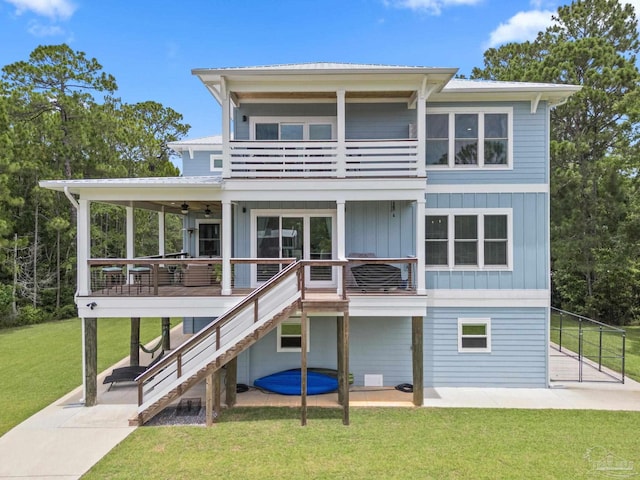 2032 Bay Point Blvd, Milton, FL 32583 - rear view of house with a balcony, board and batten siding, a lawn, stairway, and a ceiling fan