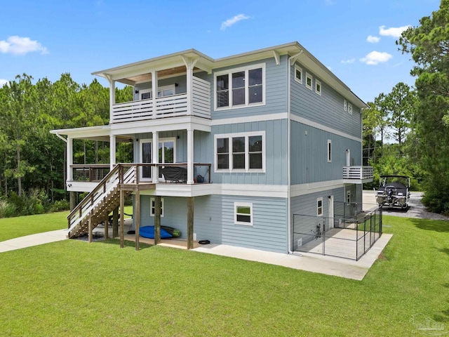 2032 Bay Point Blvd, Milton, FL 32583 - rear view of property featuring a balcony, a lawn, stairs, a patio, and board and batten siding