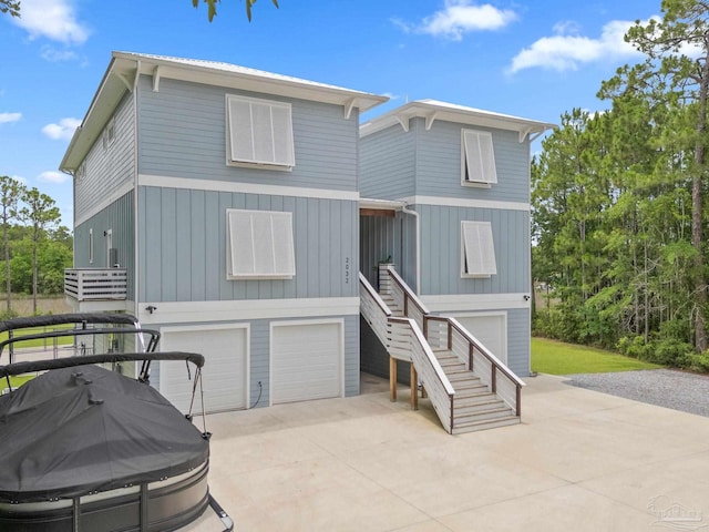 2032 Bay Point Blvd, Milton, FL 32583 - raised beach house with stairs, a garage, driveway, and board and batten siding