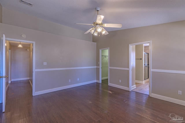 empty room featuring a textured ceiling, dark hardwood / wood-style floors, ceiling fan, and lofted ceiling