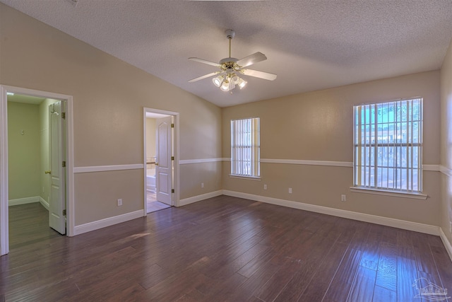 spare room with a textured ceiling, ceiling fan, dark wood-type flooring, and lofted ceiling