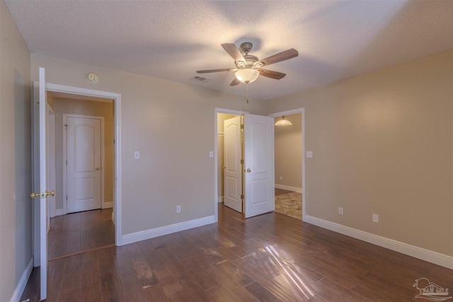 unfurnished bedroom featuring a textured ceiling, ceiling fan, and dark hardwood / wood-style floors