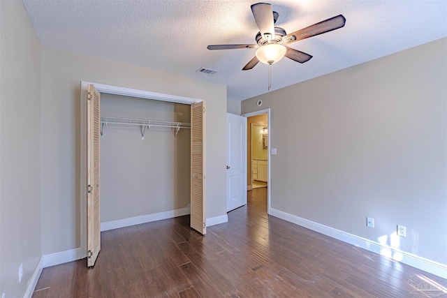 unfurnished bedroom featuring dark hardwood / wood-style flooring, ceiling fan, a closet, and a textured ceiling