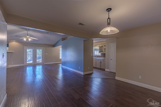 spare room with lofted ceiling with beams, ceiling fan, dark wood-type flooring, and a wealth of natural light