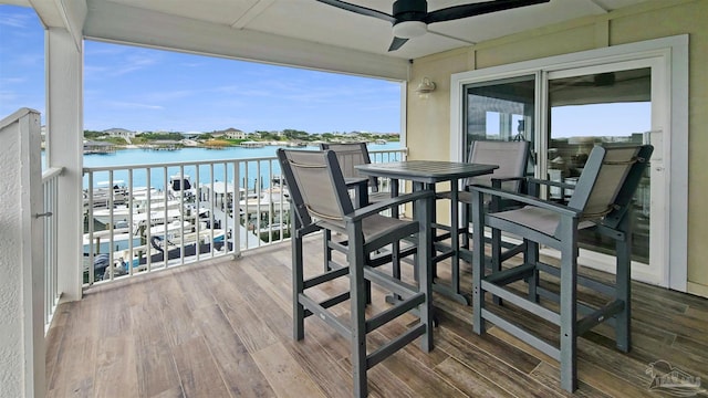 balcony with a water view and ceiling fan