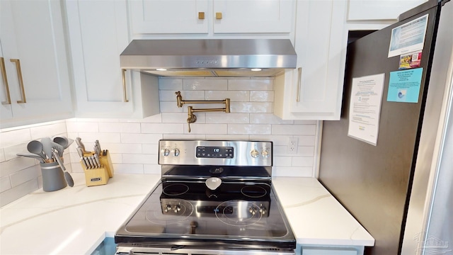 kitchen featuring appliances with stainless steel finishes, wall chimney exhaust hood, tasteful backsplash, and white cabinets