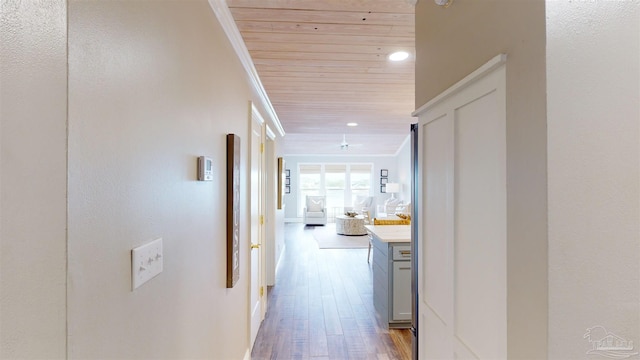 hall with crown molding, hardwood / wood-style floors, and wooden ceiling