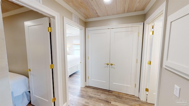 corridor featuring crown molding, light hardwood / wood-style floors, and wooden ceiling