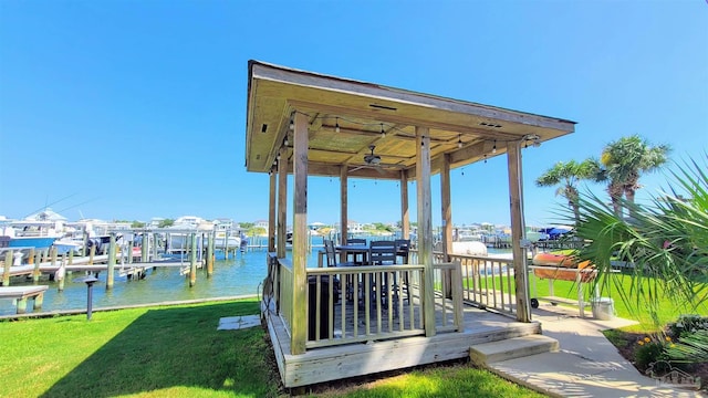 view of dock with a lawn and a water view