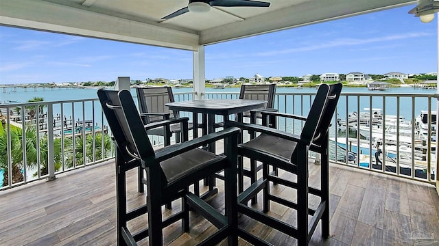 balcony featuring a water view and ceiling fan