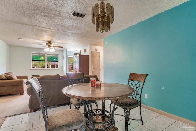 dining space featuring visible vents, a ceiling fan, light tile patterned flooring, a textured ceiling, and baseboards