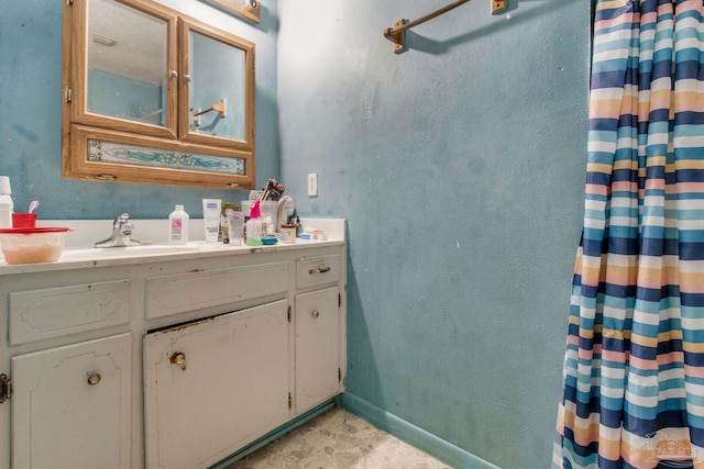 full bath featuring a sink and baseboards