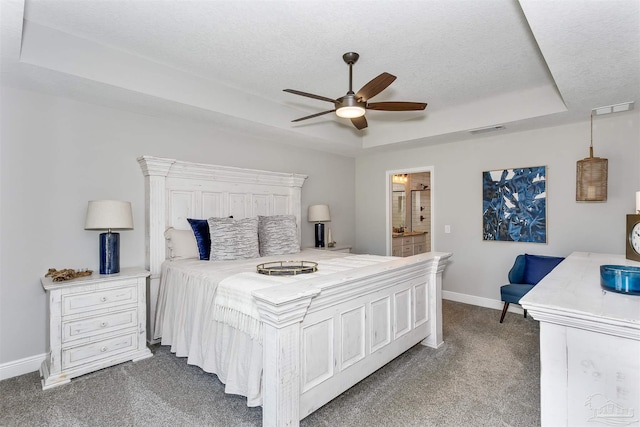 bedroom with visible vents, baseboards, a raised ceiling, dark colored carpet, and a textured ceiling