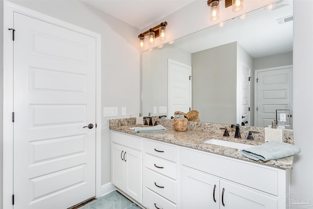 full bath with double vanity, baseboards, visible vents, and a sink