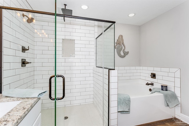 full bath featuring a stall shower, a garden tub, and vanity