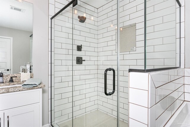 bathroom featuring visible vents, vanity, and a shower stall