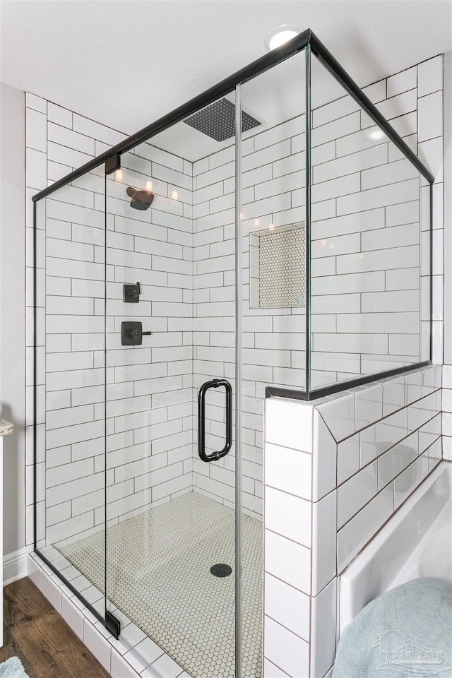 bathroom featuring a shower stall and wood finished floors