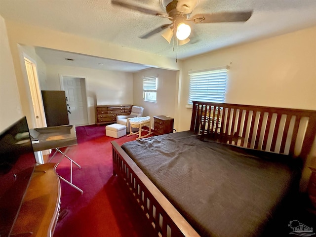 carpeted bedroom with ceiling fan and a textured ceiling