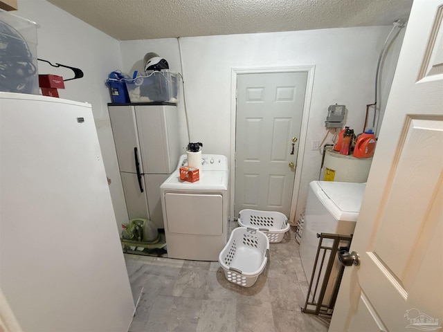 laundry room featuring a textured ceiling, washer / clothes dryer, and water heater