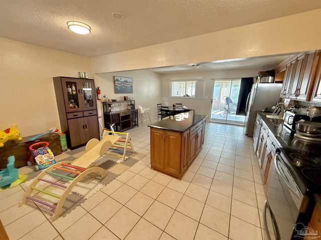 kitchen featuring light tile patterned floors, stainless steel appliances, and a textured ceiling