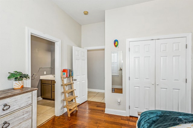 bedroom with dark hardwood / wood-style flooring, connected bathroom, and a closet