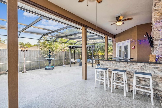 view of patio featuring an outdoor bar, ceiling fan, and a lanai