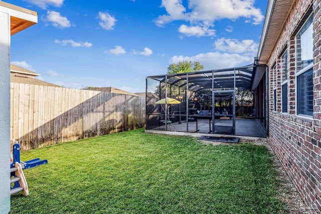 view of yard featuring glass enclosure and a patio