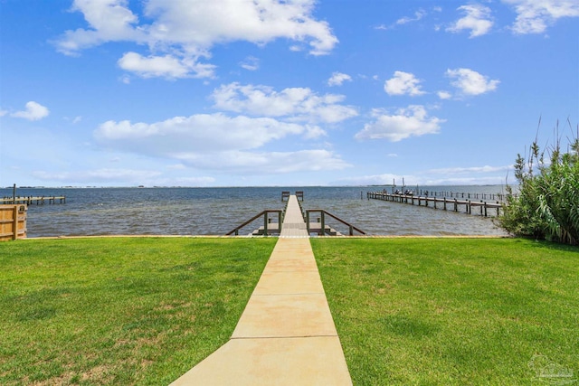 view of dock with a lawn and a water view