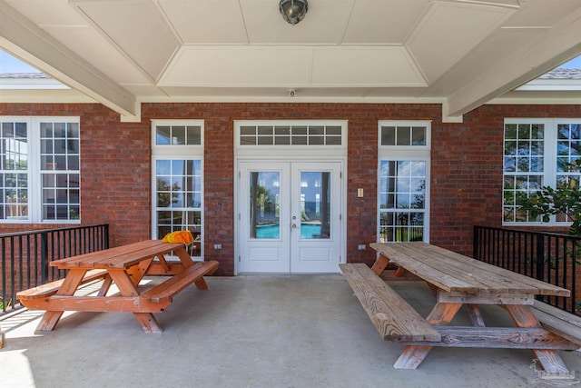 view of exterior entry featuring french doors and a patio