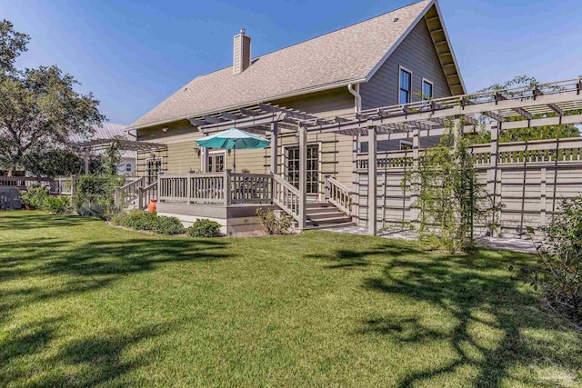 rear view of property featuring a pergola, a deck, and a lawn