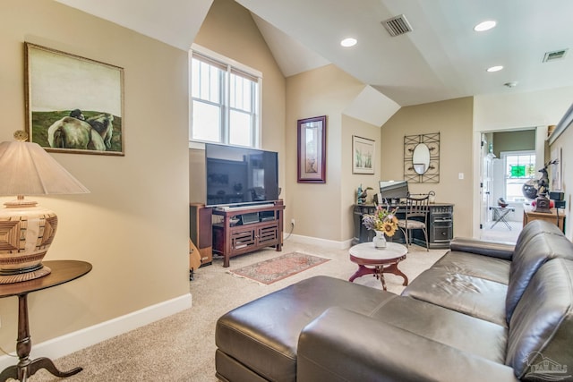 carpeted living room featuring a wealth of natural light and vaulted ceiling